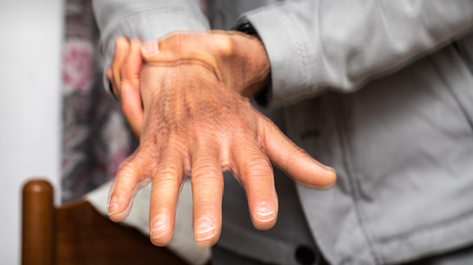 Person holding wrist, hand is shaking